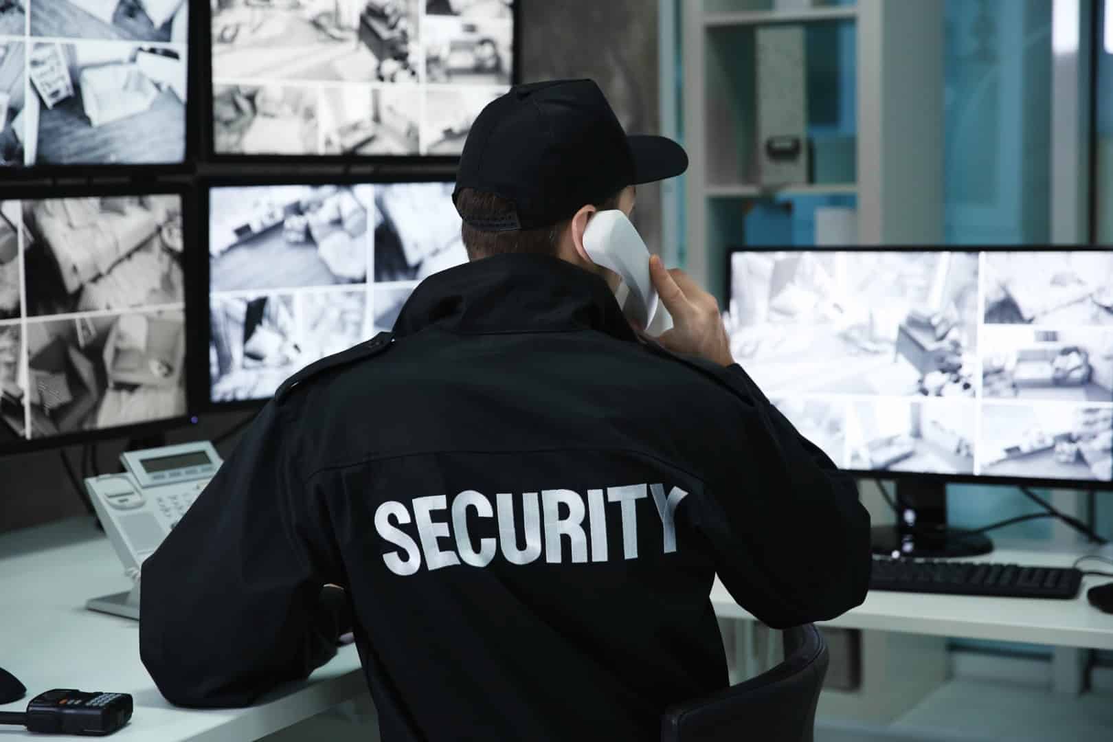 stock-photo-male-security-guard-talking-by-telephone-in-surveillance-room-1008332989